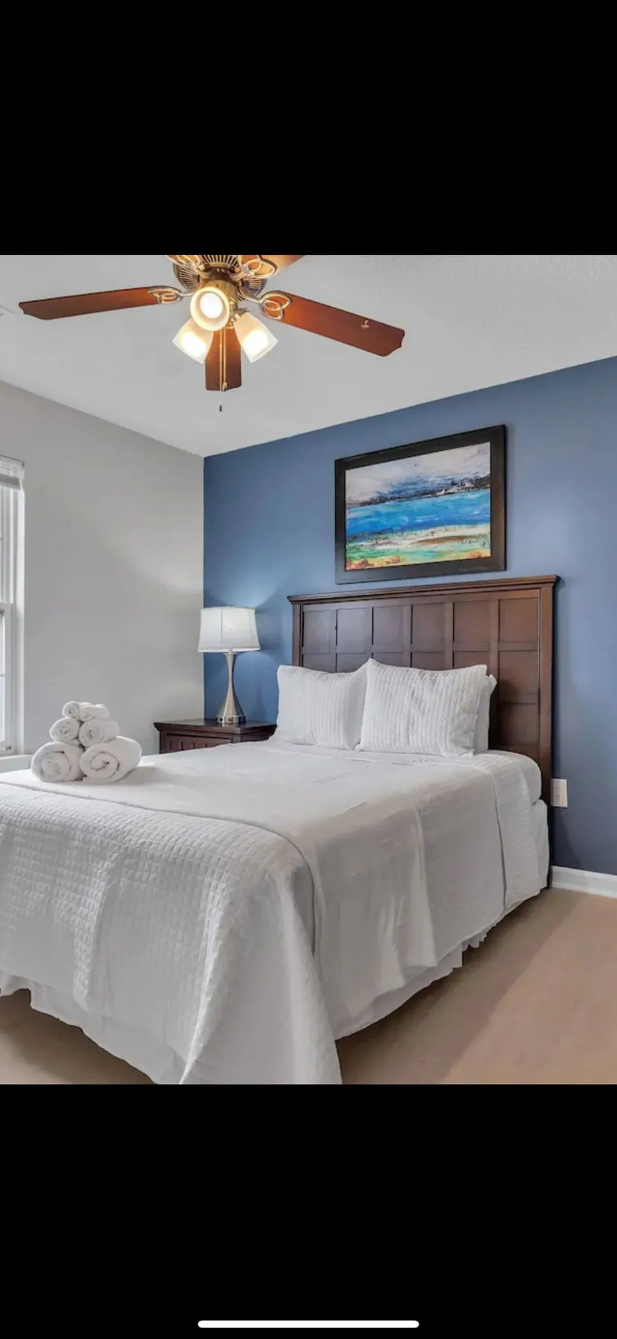 A serene bedroom scene featuring a comfortable bed adorned with soft bedding, a stylish lamp on the nightstand, and calming artwork on the wall. The overall mood is restful and tranquil, ideal for relaxation and a good night's sleep.